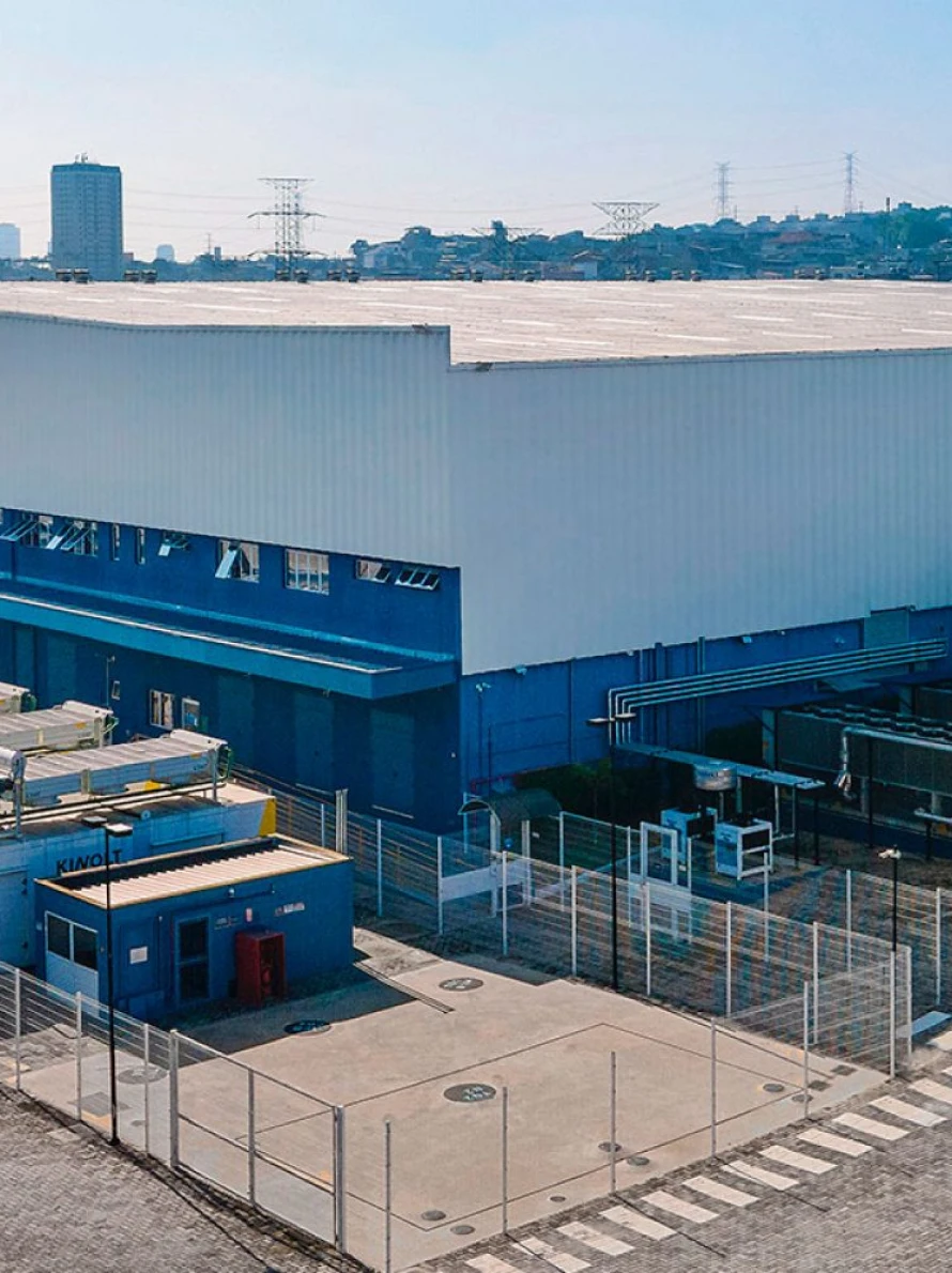 Fábrica industrial moderna em área urbana, céu limpo.