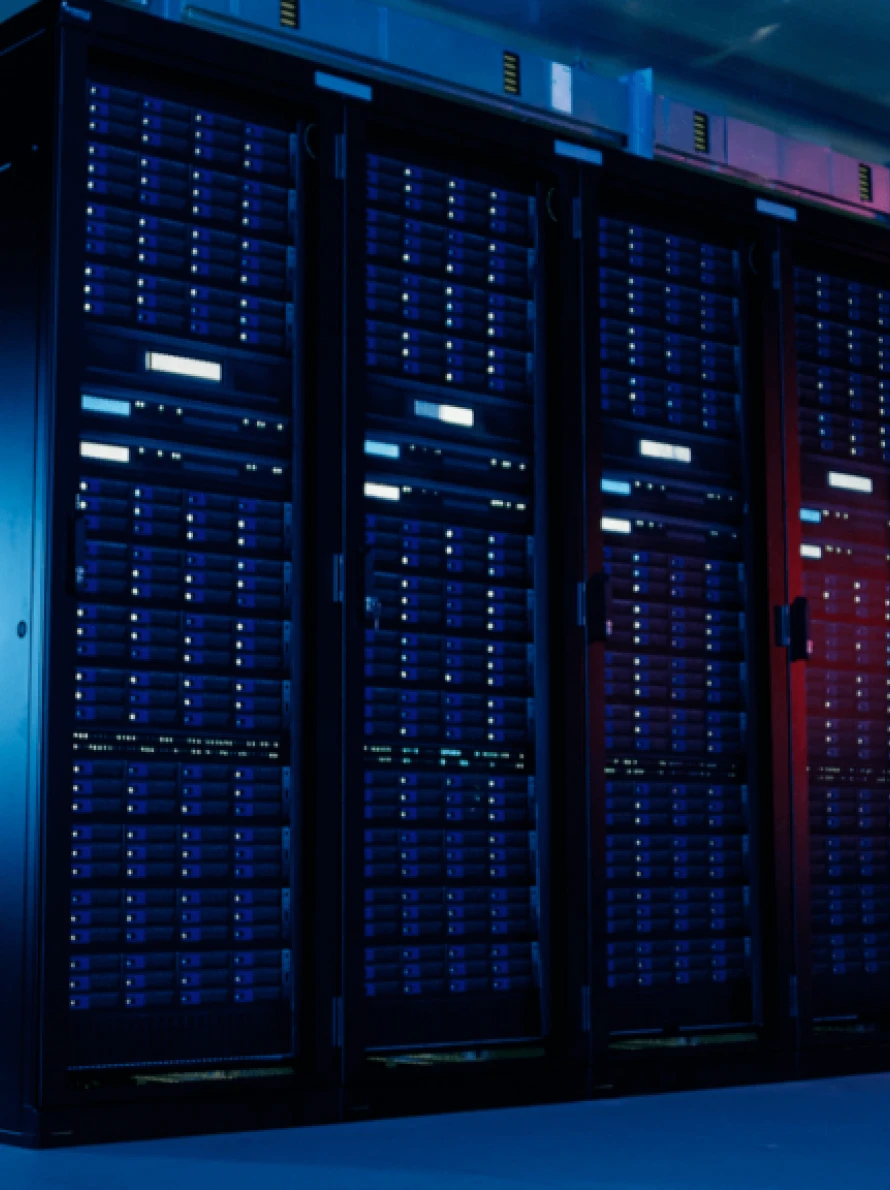 Fileiras de racks de servidores pretos com luzes LED iluminadas em um data center, vistas de frente sob iluminação azul e vermelha, mostrando um ambiente seguro e de alta tecnologia aprimorado pelo desempenho do Litespeed e pela proteção do Imunify360.