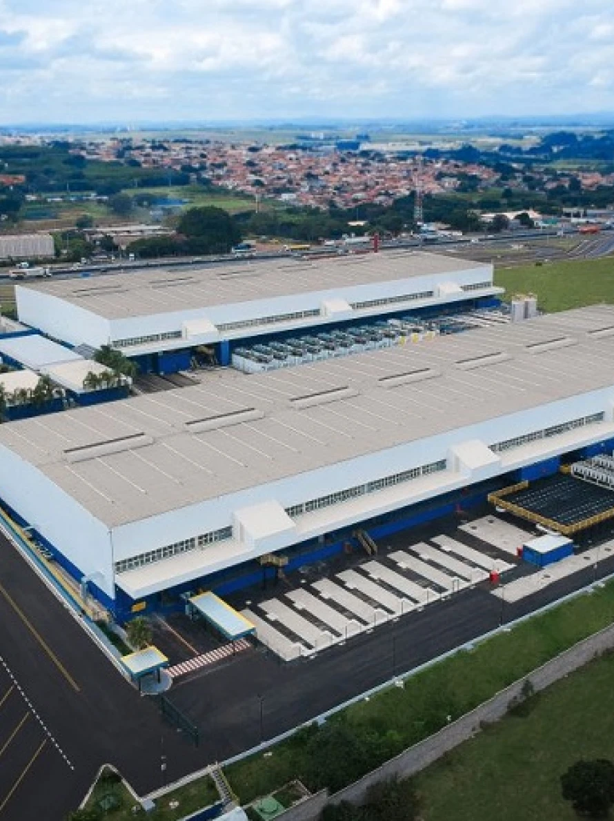 Vista aérea de grande galpão industrial em cidade.